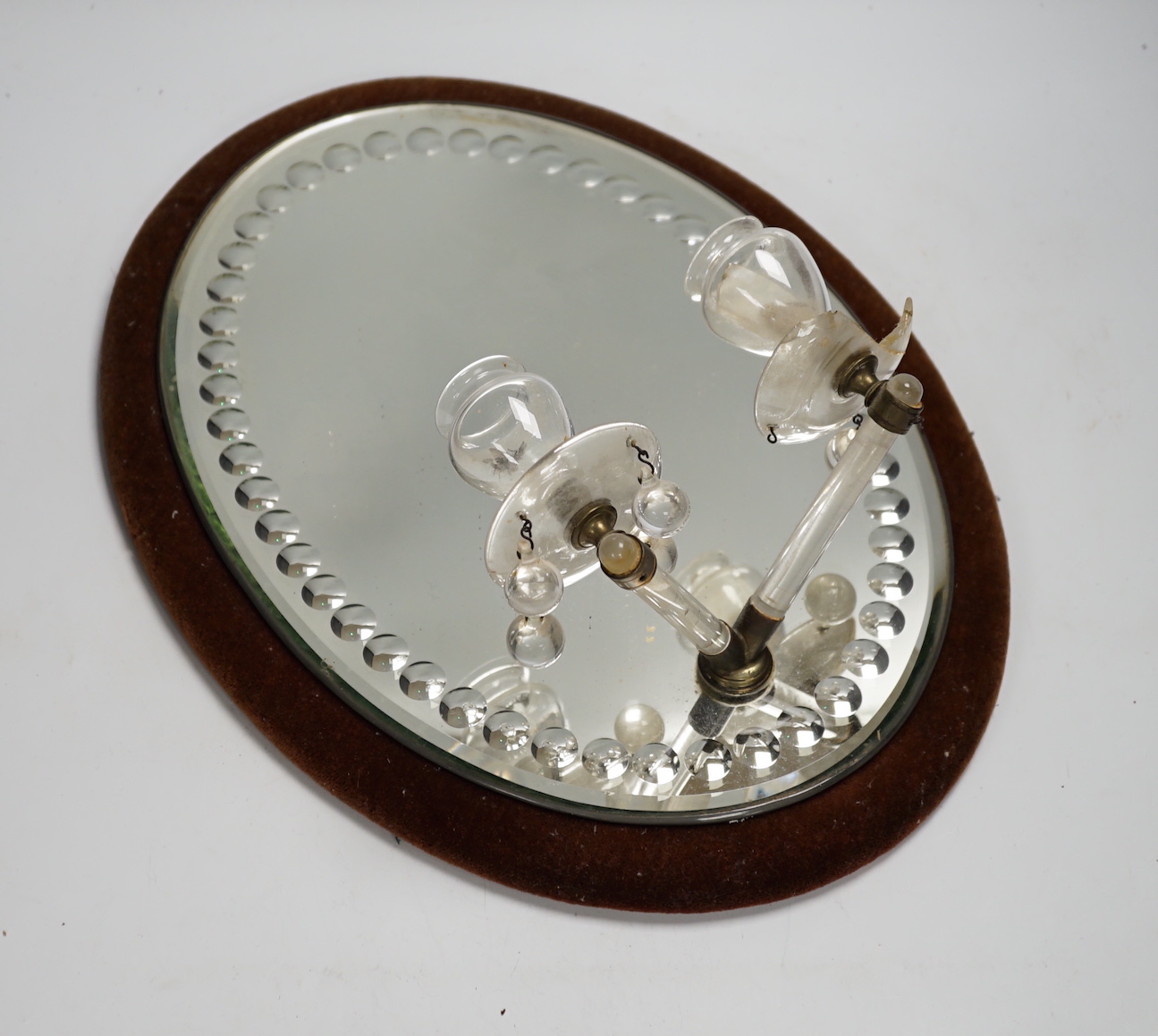 An oval mirrored twin-light girandole mirror, 46cms high